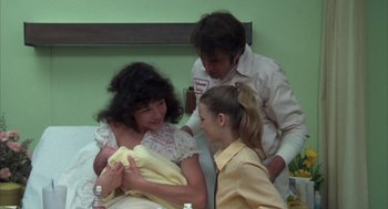 Movie still from “Melvin and Howard” (1980), directed by Jonathan Demme – A group of people standing next to each other in a room; Medium shot, Over the shoulder angle