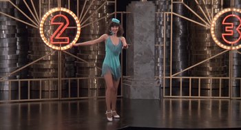 Movie still from “Melvin and Howard” (1980), directed by Jonathan Demme – A woman in a blue dress and hat on a stage; Wide shot, Low angle