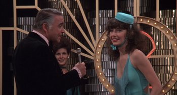 Movie still from “Melvin and Howard” (1980), directed by Jonathan Demme – A man and a woman are holding a microphone; Medium shot, Over the shoulder angle