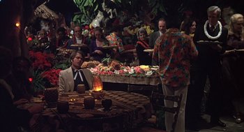 Movie still from “Melvin and Howard” (1980), directed by Jonathan Demme – A group of people gathered around a table with food on it; Wide shot, High angle