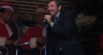 Movie still from “Melvin and Howard” (1980), directed by Jonathan Demme – A man wearing a suit and tie holding a microphone; Close Up shot, Low angle