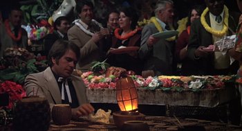 Movie still from “Melvin and Howard” (1980), directed by Jonathan Demme – A man sitting at a table in front of a crowd; Medium shot, High angle