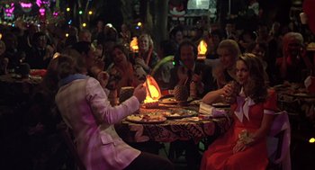 Movie still from “Melvin and Howard” (1980), directed by Jonathan Demme – A group of people sitting around a table with food on top of it; Wide shot, Over the shoulder angle