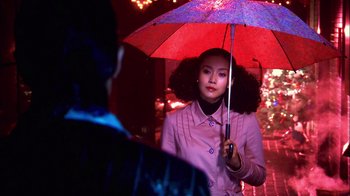 A woman holding an umbrella while standing next to a man