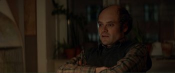 Movie still from “Men & Chicken” (2015), directed by Anders Thomas Jensen – A man with a bald head is posing for a picture; Close Up shot, Over the shoulder angle