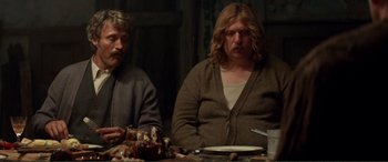 Movie still from “Men & Chicken” (2015), directed by Anders Thomas Jensen – Two people sitting at a table with food; Medium shot, High angle