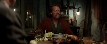 Movie still from “Men & Chicken” (2015), directed by Anders Thomas Jensen – A man sitting at a table with a bowl of food in front of him; Medium shot, Over the shoulder angle