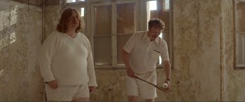 Movie still from “Men & Chicken” (2015), directed by Anders Thomas Jensen – A man and a woman playing a game of croquet; Medium shot, Low angle