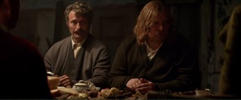 Movie still from “Men & Chicken” (2015), directed by Anders Thomas Jensen – Two people sitting at a table with food; Medium shot, Over the shoulder angle