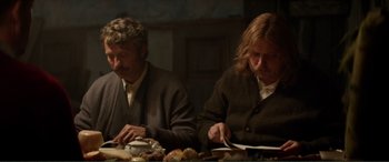 Movie still from “Men & Chicken” (2015), directed by Anders Thomas Jensen – A man and a woman sitting at a dinner table; Medium shot, Low angle