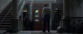 Movie still from “Men & Chicken” (2015), directed by Anders Thomas Jensen – A man and a woman standing in front of a door; Wide shot, Low angle