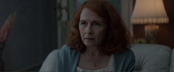 Movie still from “Men & Chicken” (2015), directed by Anders Thomas Jensen – An older woman with red curly hair looking at the camera; Close Up shot, Over the shoulder angle