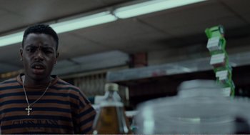 Movie still from “Menace II Society” (1993), directed by Albert Hughes – A man standing in front of an oven in a kitchen; Close Up shot, Over the shoulder angle