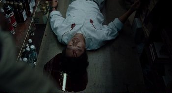 Movie still from “Menace II Society” (1993), directed by Albert Hughes – A woman with blood on her face lies on the floor; Medium shot, Overhead angle