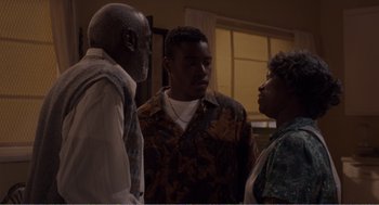 Movie still from “Menace II Society” (1993), directed by Albert Hughes – A group of three people standing next to each other; Medium shot, Over the shoulder angle