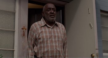 Movie still from “Menace II Society” (1993), directed by Albert Hughes – An older man standing in front of a door; Medium shot, Low angle