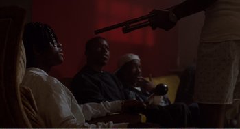 Movie still from “Menace II Society” (1993), directed by Albert Hughes – A group of people sitting in a living room; Medium shot, Over the shoulder angle