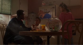 Movie still from “Menace II Society” (1993), directed by Albert Hughes – Three children sitting at a table in a kitchen; Medium shot, High angle