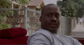 Movie still from “Menace II Society” (1993), directed by Albert Hughes – A person sitting in a chair; Close Up shot, Low angle