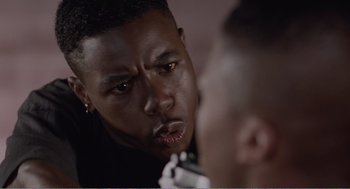 Movie still from “Menace II Society” (1993), directed by Albert Hughes – A person looking at a person in a mirror; Close Up shot, Over the shoulder angle