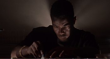 Movie still from “Menace II Society” (1993), directed by Albert Hughes – A young man is playing video games in the dark; Close Up shot, Low angle