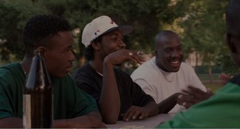 Movie still from “Menace II Society” (1993), directed by Albert Hughes – A group of young men sitting at a picnic table; Medium shot, High angle