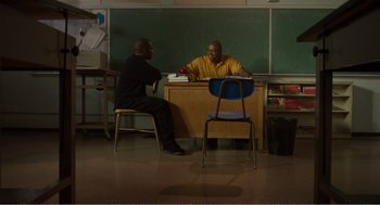 Movie still from “Menace II Society” (1993), directed by Albert Hughes – Two men are sitting at a desk in a classroom; Wide shot, High angle