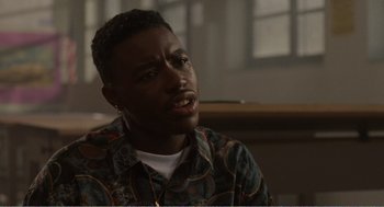 Movie still from “Menace II Society” (1993), directed by Albert Hughes – A man sitting in front of a window with his mouth open; Close Up shot, Over the shoulder angle