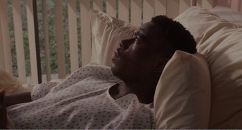 Movie still from “Menace II Society” (1993), directed by Albert Hughes – A man laying in a hospital bed looking up at the sky; Medium shot, High angle