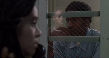 Movie still from “Menace II Society” (1993), directed by Albert Hughes – A man and a woman looking out of a jail cell; Close Up shot, Over the shoulder angle