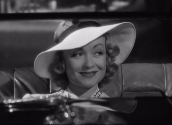 A black and white photo of a woman wearing a hat