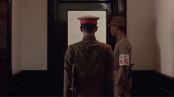 Movie still from “Merry Christmas Mr. Lawrence” (1983), directed by Nagisa Ôshima – Two men in military uniforms standing in front of a door; Medium shot, Low angle