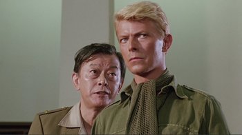 Movie still from “Merry Christmas Mr. Lawrence” (1983), directed by Nagisa Ôshima – A man and a woman standing next to each other; Close Up shot, Over the shoulder angle