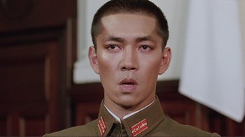 Movie still from “Merry Christmas Mr. Lawrence” (1983), directed by Nagisa Ôshima – A man in a military uniform is looking straight ahead; Close Up shot, Low angle