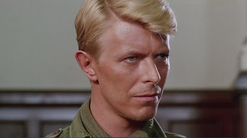 Movie still from “Merry Christmas Mr. Lawrence” (1983), directed by Nagisa Ôshima – A person wearing a military uniform; Close Up shot, Over the shoulder angle