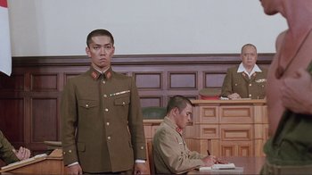 Movie still from “Merry Christmas Mr. Lawrence” (1983), directed by Nagisa Ôshima – Two men in military uniforms stand in front of a judge in a courtroom; Medium shot, Low angle