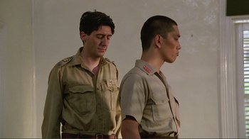 Movie still from “Merry Christmas Mr. Lawrence” (1983), directed by Nagisa Ôshima – Two men standing next to each other in uniform; Medium shot, Low angle