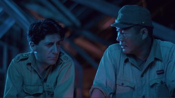 Movie still from “Merry Christmas Mr. Lawrence” (1983), directed by Nagisa Ôshima – Two men are sitting next to each other; Close Up shot, Over the shoulder angle