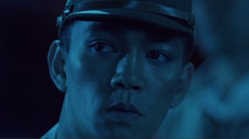 Movie still from “Merry Christmas Mr. Lawrence” (1983), directed by Nagisa Ôshima – A person wearing a hat; Close Up shot, Low angle