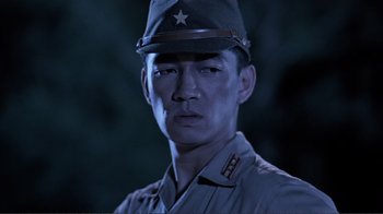 Movie still from “Merry Christmas Mr. Lawrence” (1983), directed by Nagisa Ôshima – A man wearing a uniform and a hat; Close Up shot, Low angle