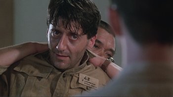 Movie still from “Merry Christmas Mr. Lawrence” (1983), directed by Nagisa Ôshima – A man in a military uniform is being hugged by another man in a military uniform; Close Up shot, Over the shoulder angle