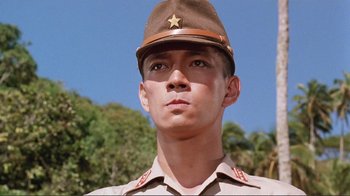 Movie still from “Merry Christmas Mr. Lawrence” (1983), directed by Nagisa Ôshima – A man in a uniform is looking at the camera; Close Up shot, Low angle