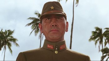 Movie still from “Merry Christmas Mr. Lawrence” (1983), directed by Nagisa Ôshima – A person wearing a military uniform; Close Up shot, Low angle