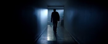 Movie still from “Metallica Through the Never” (2013), directed by Nimród Antal – A man walking down a hallway in a dark room; Wide shot, Low angle