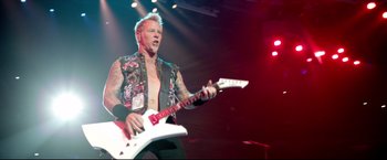 A man with a white guitar in a concert setting