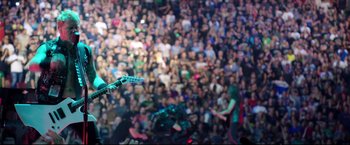 Movie still from “Metallica Through the Never” (2013), directed by Nimród Antal – A crowd of people in a large room; Extreme Wide shot, High angle