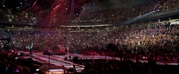 Movie still from “Metallica Through the Never” (2013), directed by Nimród Antal – A large crowd of people in a large stadium; Extreme Wide shot, High angle