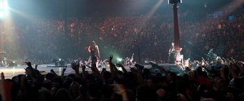 Movie still from “Metallica Through the Never” (2013), directed by Nimród Antal – A crowd of people in a large room with lights on; Wide shot, High angle