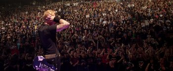 Movie still from “Metallica Through the Never” (2013), directed by Nimród Antal – A large crowd of people are gathered in front of a stage; Wide shot, High angle
