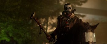 Movie still from “Metallica Through the Never” (2013), directed by Nimród Antal – A man in a gas mask holding an axe; Medium shot, Low angle
